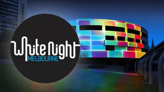 A vibrant building in Melbourne is illuminated with colorful patterns, showcasing an engaging light display typical of the White Night festival. The logo for "White Night Melbourne" overlays the image, emphasizing the event's identity.